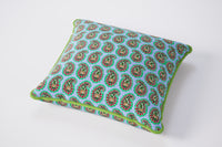 Decorative pillow with a green and red pattern on a white background